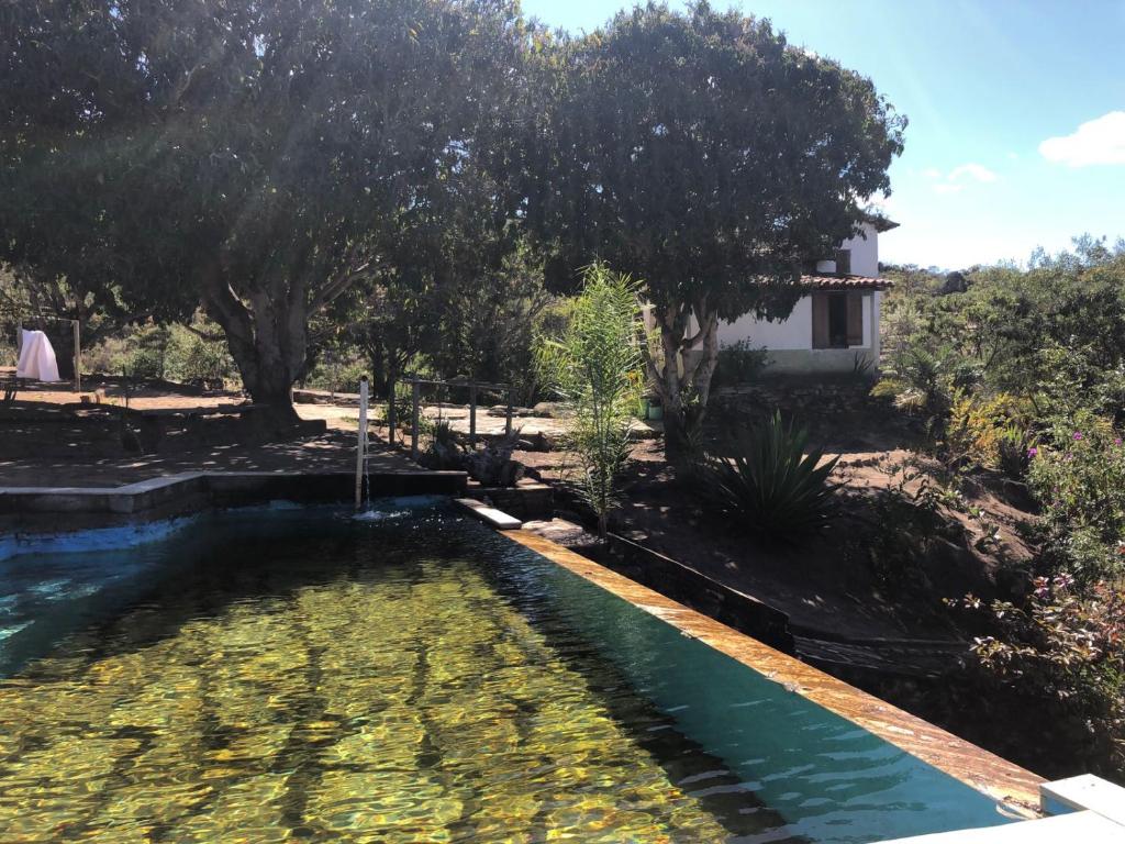 Piscina natural da Estância do Biribiri com casario rústico e vista para a serra